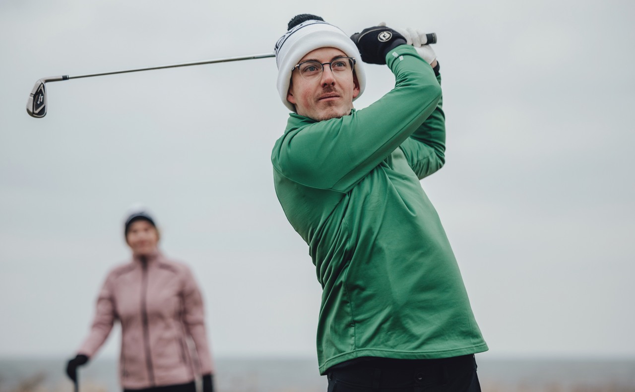 A man swinging his golf club at Trelleborg's Golf Club.