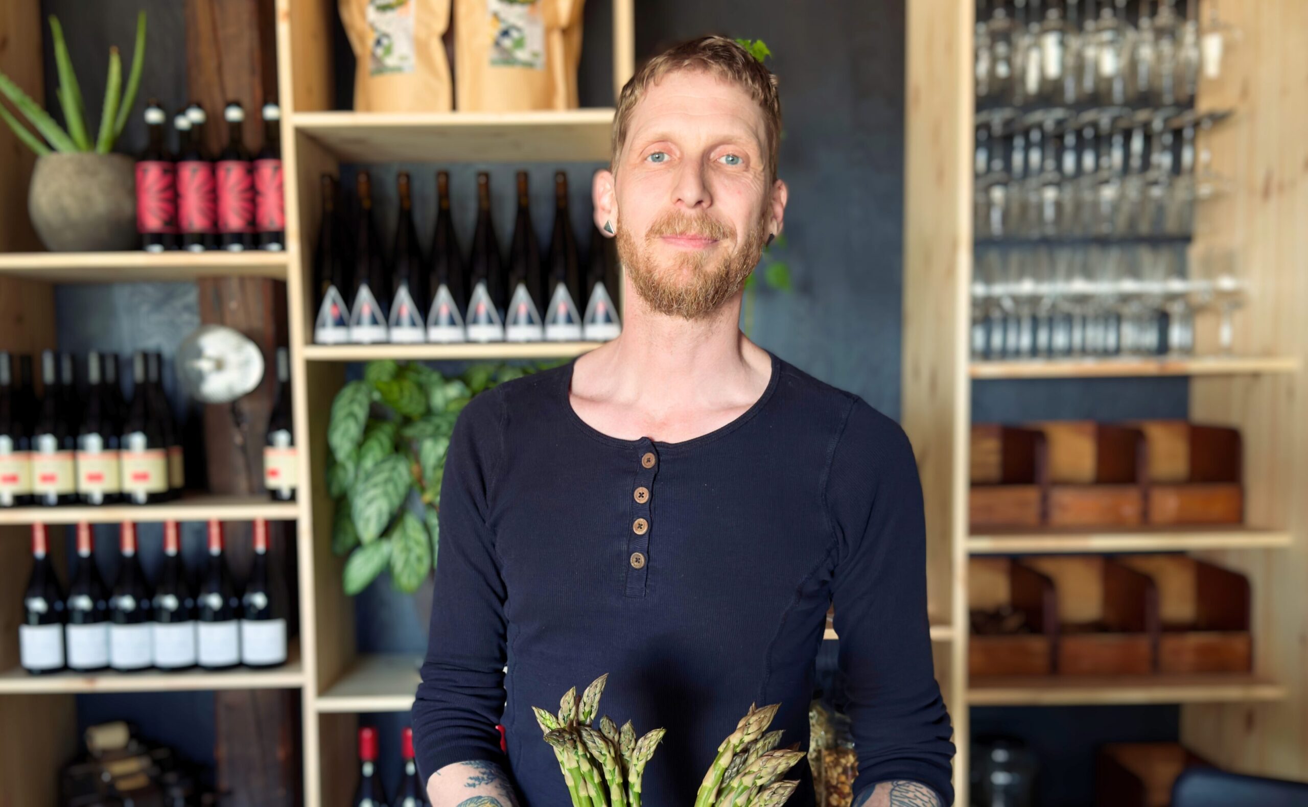 Martin håller i sparris och står i sin restaurang.