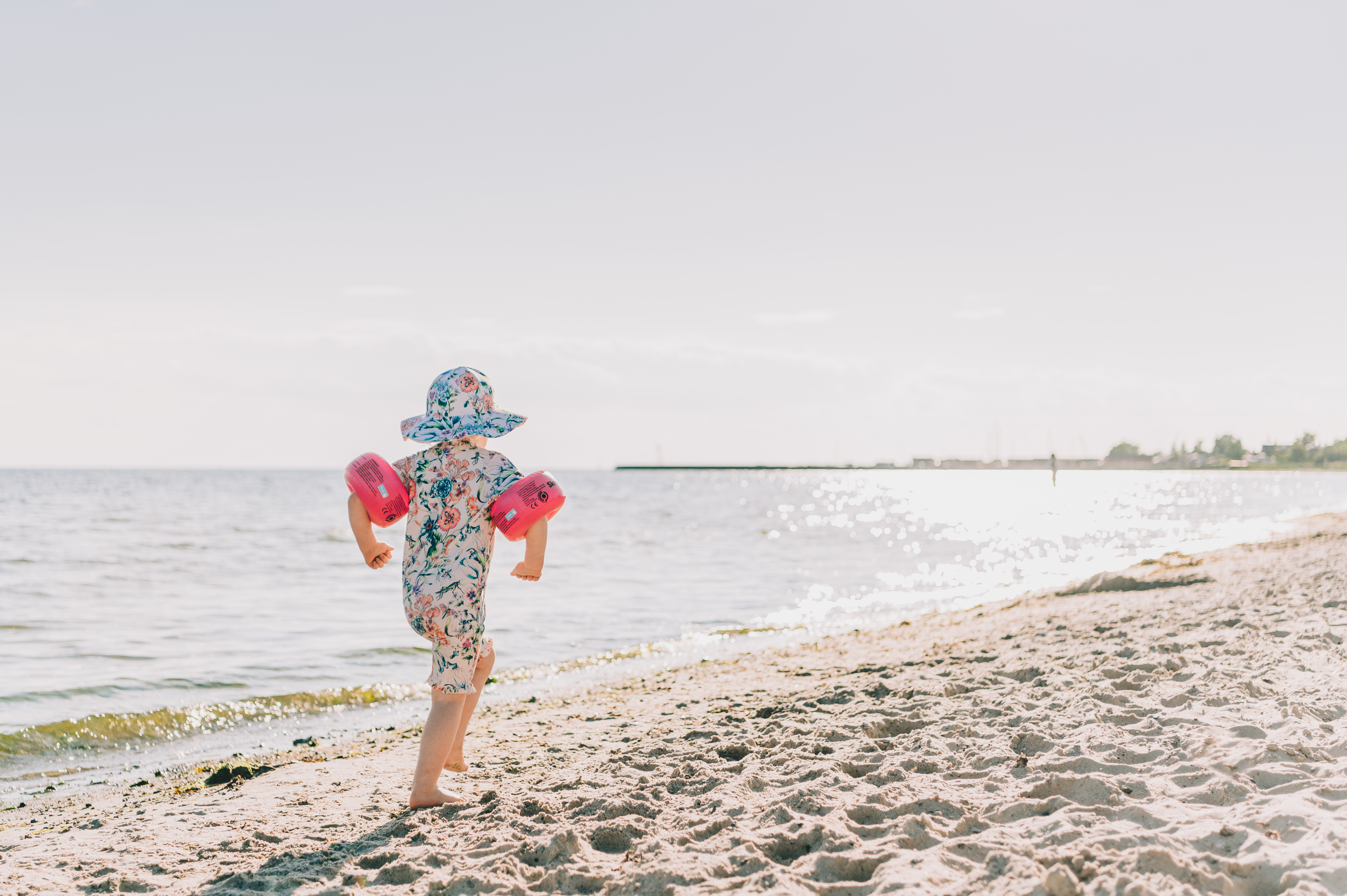 Liten flicka springer på stranden
